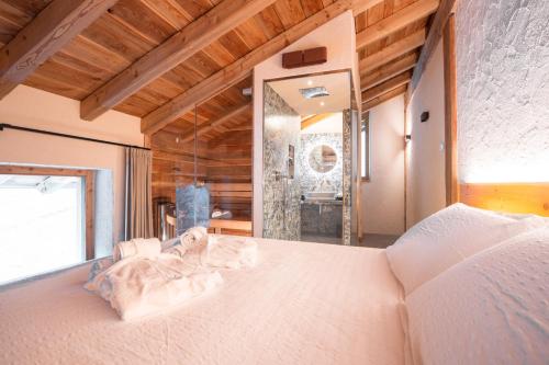 莱德罗Chalet Noèr的卧室配有一张白色大床和镜子