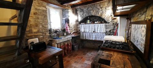 Frassinorob&b La Corte dei Cerri- Il Piccolo Chalet的厨房设有石墙和炉灶。