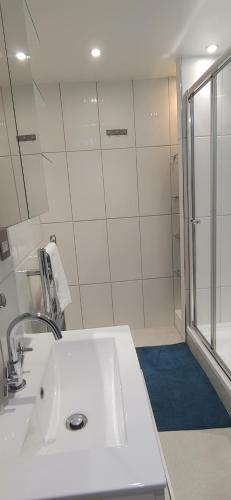 伦敦Comfortable Room With Ensuite的白色的浴室设有水槽和淋浴。