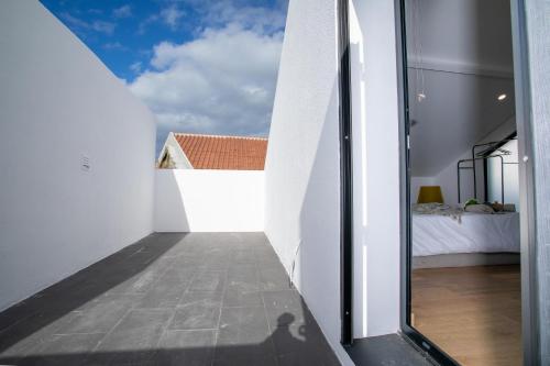ArrifesCarvão Pdl Inn的从房子的走廊上可欣赏到卧室的景色