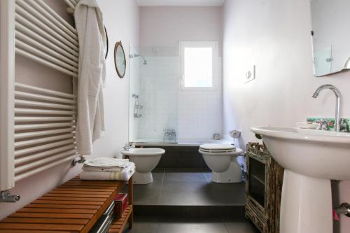 米兰LOVELY MILANO - Beautiful loft with terrace in Porta Romana的浴室配有2个卫生间、浴缸和水槽