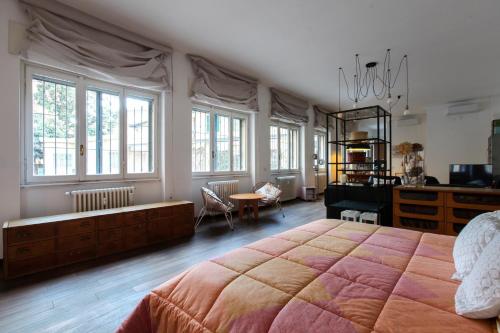 米兰LOVELY MILANO - Beautiful loft with terrace in Porta Romana的一间卧室配有一张大床、一张书桌和窗户。