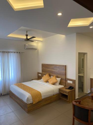 蒙纳Munnar Ice Queen Resorts的一间卧室配有一张大床和一张桌子