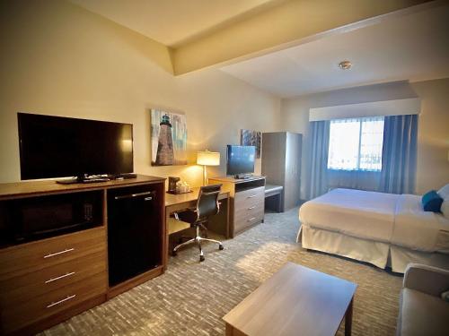 Brockport多林格酒店及套房的酒店客房配有一张床和一张书桌及一台电视