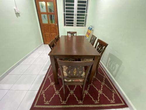 马日丹那Green House Homestay的一间带木桌和椅子的用餐室