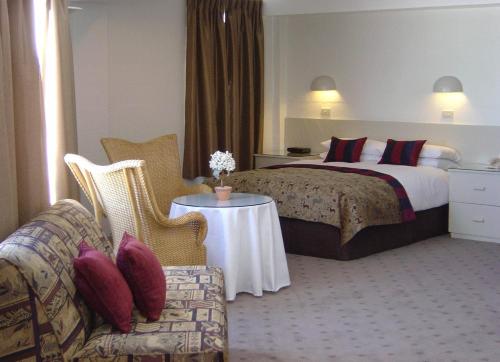 佩里舍峡谷瑞雪庄园酒店的酒店客房配有床、沙发和桌子。