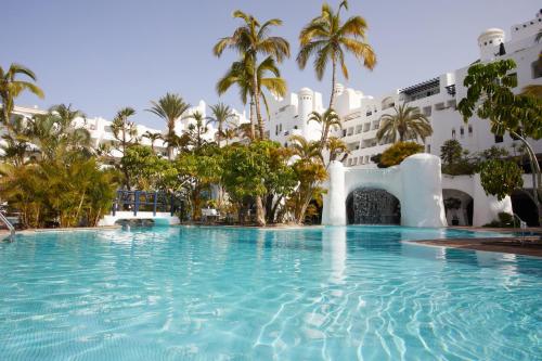 阿德耶Dreams Jardin Tropical Resort & Spa的大楼前的大型游泳池