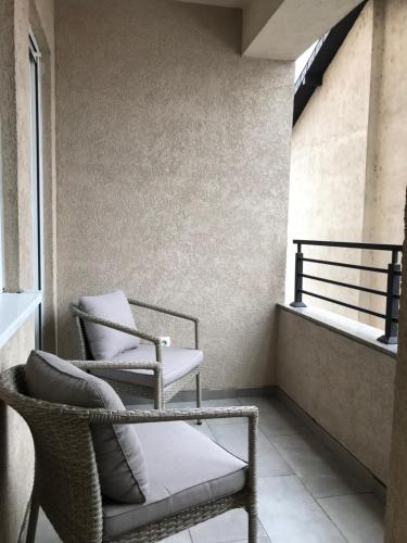 新帕扎尔Green Apartment的两把椅子坐在带窗户的阳台