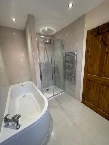 雷克瑟姆Merlin House的设有带浴缸和淋浴的浴室。