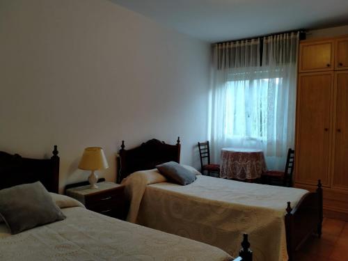 SeoaneCasa da Fontiña的一间卧室设有两张床和窗户。