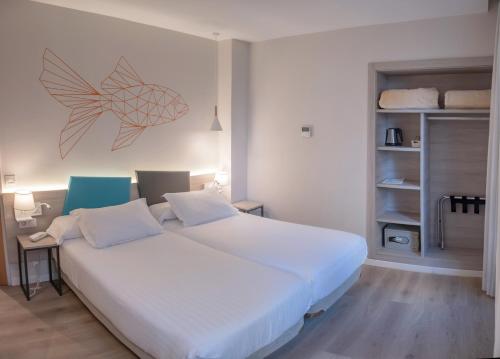 瓦伦西亚瓦伦西亚梅迪特拉内奥酒店的一间卧室设有两张床,墙上有一条鱼