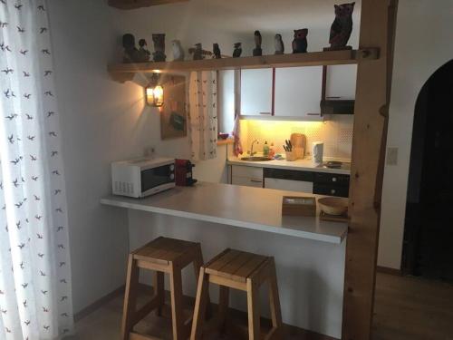基茨比厄尔Gundhabing flat的一个带柜台和两张凳子的小厨房
