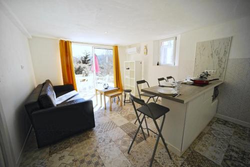 博迪昂Les quatre chênes的客厅设有厨房和桌椅