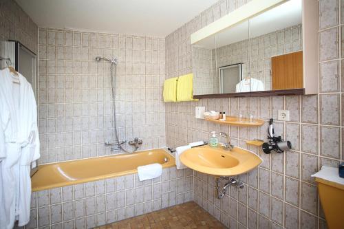 苏尔茨堡Landgasthof Rebstock的浴室配有黄色浴缸和水槽