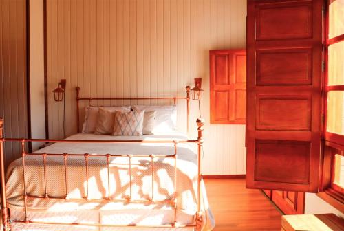 本图贡萨尔维斯Casarão do Vale dos Vinhedos的一间卧室配有一张床,铺有木地板