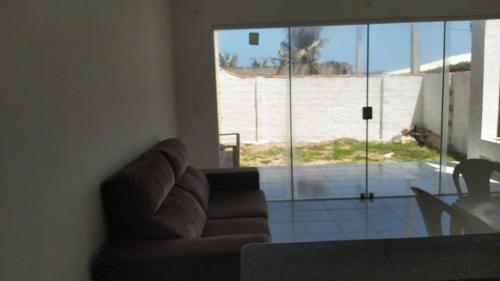 尼西亚弗洛雷斯塔DUPLEX BEIRA MAR TABATINGA的带沙发的客厅,享有海滩美景