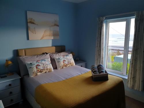 科克Idyllic Inchydoney Beach Cottage - Amazing sea views, path to beach!的一间卧室设有一张大床和大窗户