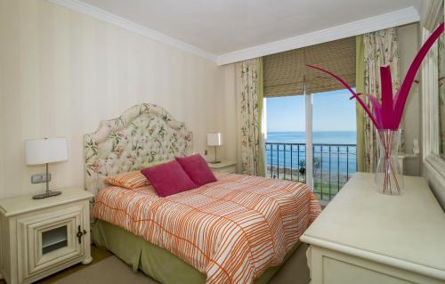 EsteponaHB Comfortable Beachfront Holiday Apartment的一间卧室设有一张床和一个海景阳台