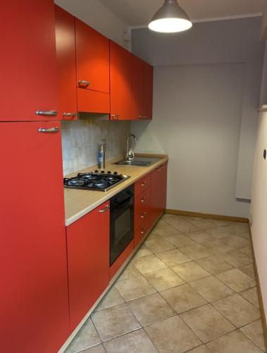 福利尼奥Silio 12的厨房配有红色橱柜和炉灶烤箱