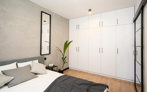 比得哥什Apartament Nakielska 46a lux 40m2的卧室配有白色橱柜和大床