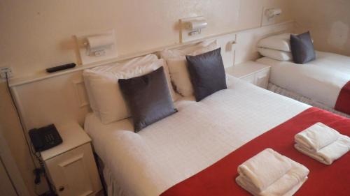 伦敦阿兰大楼酒店的一间小客房内配有两张床的卧室
