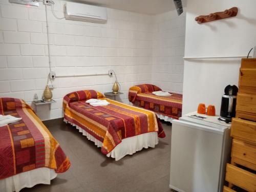 库拉布罗切罗镇Hostería El Peregrino的客房设有两张床和一台冰箱。