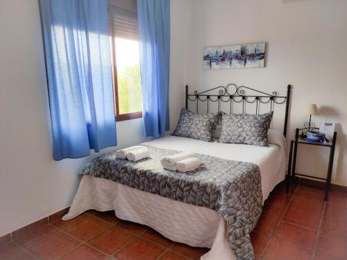 Villanueva del FresnoCasa Rural La Aduana的一间卧室配有一张床,上面有两条毛巾