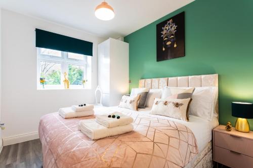 哈特菲尔德'The Butterfly' - An Elegant 2 Bed Apartment in a quiet location in Hatfield- Near Business Park and University - Free Allocated Parking - Fast Wi-fi的一间卧室设有一张带绿色墙壁的大床