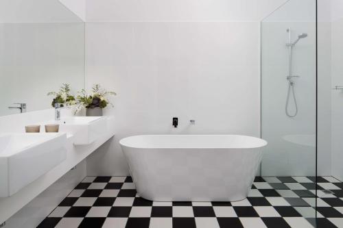 霍巴特霍巴特莱吉斯酒店的白色的浴室设有2个盥洗盆和1个浴缸。