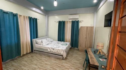 达沃市Charming Apartelle with Swimming Pool -Exclusive的小房间设有一张床和一张桌子