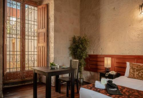 阿雷基帕La Casa de Melgar的一间卧室配有桌子、床和书桌