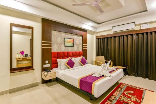 西里古里Mount Amara Hotel & Spa, Siliguri的一间卧室配有一张大床和镜子