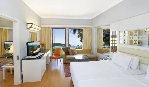 珍南海滩Holiday Villa Resort & Beachclub Langkawi的一间带白色床的卧室和一间客厅