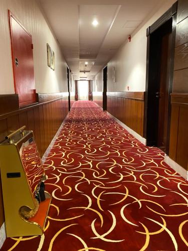 泰布克Biz Hotel Apartments的走廊上铺有红色和金色图案的地毯