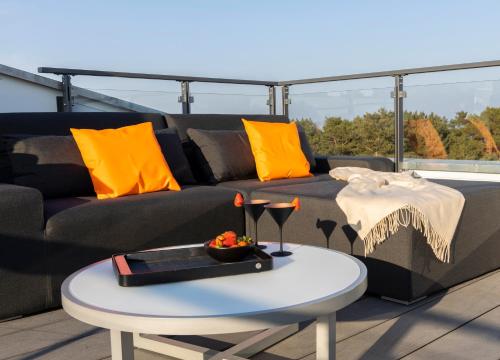 宾茨Penthouse am Südstrand - Dachterrasse mit Meerblick und Gasgrill, Klimaanlage, Luxus-Design-Apartment, 2 Minuten zum Strand, Strandkorb的客厅配有沙发和桌子