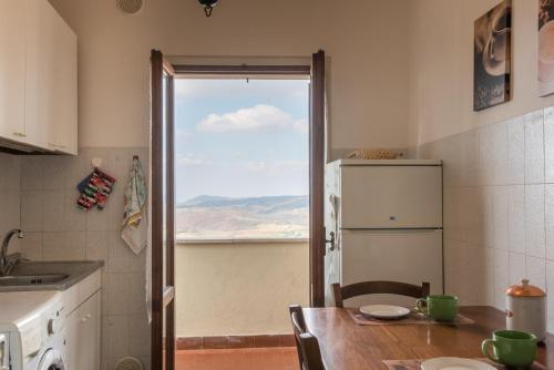 蒙特普齐亚诺La Zia Marisa的厨房配有桌子、冰箱和窗户。