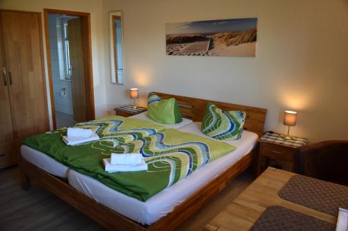比苏姆Hotel Haus am Meer的一间卧室配有一张带绿床单和枕头的床。