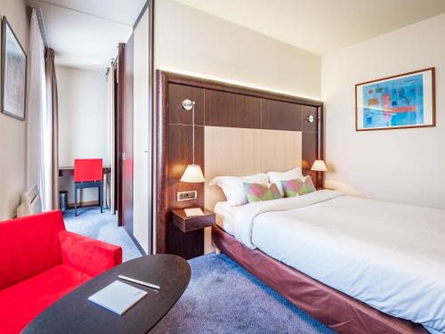 安锡邦留酒店的酒店客房,配有一张床和一张红色椅子