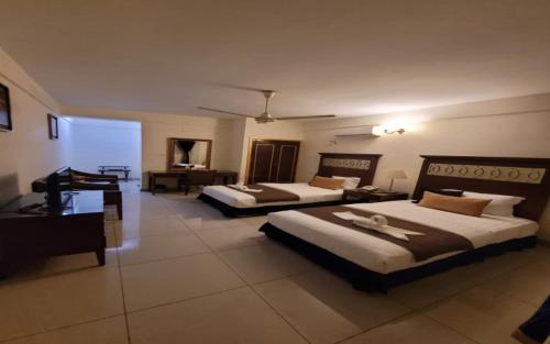 吉布提Ras Dika Hotel的酒店客房配有两张床和一张书桌