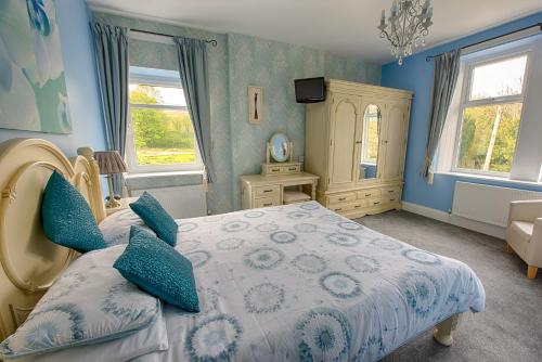 戈斯兰Halmer Grange Guest House的一间卧室设有床铺、蓝色的墙壁和窗户。