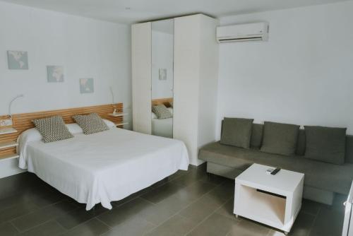 萨阿拉德洛斯阿图内斯Apartamentos ZHR 2的卧室配有白色的床和沙发