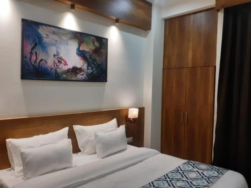 范兰德凡The Govindam Resort的卧室配有一张床,墙上挂有绘画作品