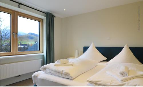 黑林山区贝尔瑙Haus Weitblick - Fewo Herzogenhorn - Bernau, Schwarzwald的一间卧室配有两张床、毛巾和窗户