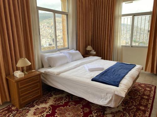 纳布卢斯Hayat Guest House的一间卧室设有一张大床和大窗户