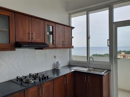 代希瓦勒New 2 bedroom apartment, 100m away from the beach的厨房配有炉灶、水槽和窗户。