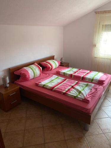 波尔吉察Apartmani Sabljic的一间卧室配有一张带红色床单和枕头的床。