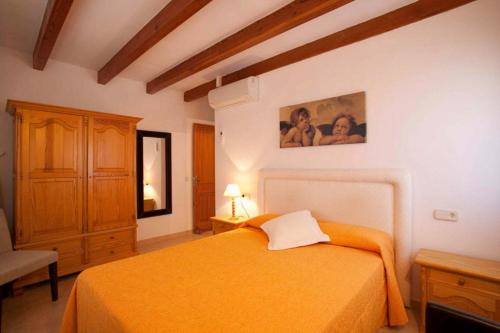 波连斯萨Serelleta的一间卧室配有橙色的床和梳妆台