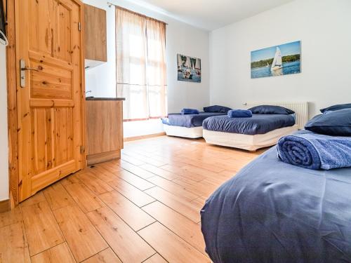 伊拉华SSW Grand Hostel Iława的一间卧室设有两张床,铺有木地板