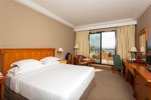 突尼斯Barceló Concorde Les Berges du Lac的配有一张床、一张书桌和一扇窗户的酒店客房
