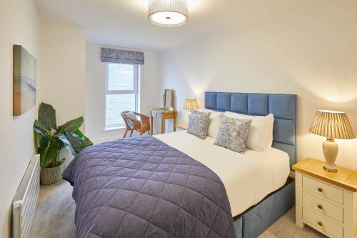 惠特利湾Host & Stay - 3 Queens Court的一间卧室设有一张大床和一个窗户。
